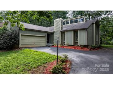 Inviting exterior of a two-story home featuring an attached garage, chimney, and well-maintained landscaping at 1748 4Th Street Ne Ct, Hickory, NC 28601