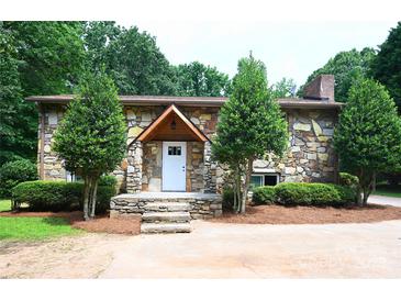 Charming stone home featuring a covered front porch and manicured landscaping at 1810 Highway 55 W Hwy, Clover, SC 29710