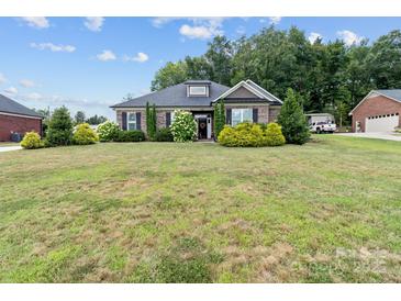 Charming single-story brick home with a large front lawn and well-maintained landscaping and black shutters at 203 Poplins Grove Church Rd, Albemarle, NC 28001