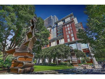Beautiful brick building and park area with statues and lush landscaping on a sunny day at 435 S Tryon St, Charlotte, NC 28202