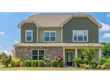 Charming two-story home features stone accents, a covered porch, and well-maintained landscaping at 1012 Leland Dr, Wesley Chapel, NC 28104