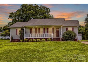 Charming single-story home features a welcoming front porch and a well-manicured lawn at 189 Lochshire Ln, Woodleaf, NC 27054
