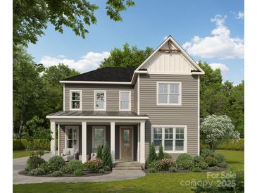 Charming two-story home featuring gray siding, a welcoming front porch, and professionally landscaped yard at 19036 Newburg Hill Rd, Davidson, NC 28036