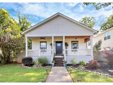 Charming home featuring a cozy front porch with ceiling fan and a beautifully landscaped yard at 323 Keswick Ave, Charlotte, NC 28206