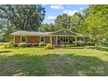 Charming brick home with a well-manicured lawn and beautiful landscaping at 8101 Truelight Church Rd, Mint Hill, NC 28227