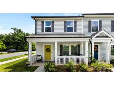 Charming front porch with a yellow door and a welcoming wreath, enhancing the curb appeal of this lovely townhome at 1101 Plaza Walk Dr, Charlotte, NC 28215