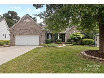 Charming brick home with well-manicured lawn and mature landscaping, creating excellent curb appeal at 1119 Williamstown Rd, Matthews, NC 28105