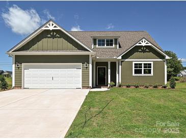 Charming home with a white garage door and beautifully landscaped front yard at 11533 Valley Oak Ln, Stanfield, NC 28163