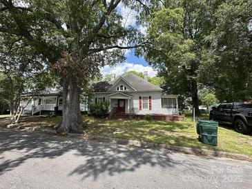 Charming home featuring a red door and shutters, complemented by mature trees in a yard at 118 Hemphill Ave, Chester, SC 29706