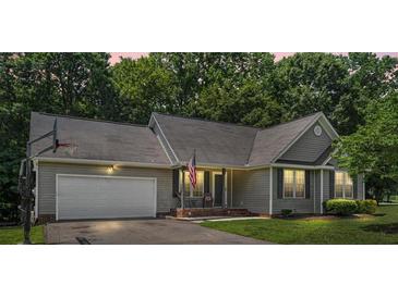 Charming single-story home with gray siding, well-manicured lawn, and inviting front porch at 124 Turning Leaf Ln, Statesville, NC 28677