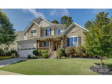 Charming two-story home with stone accents, a wooden porch, and a well-manicured lawn at 17537 Caddy Ct, Charlotte, NC 28278