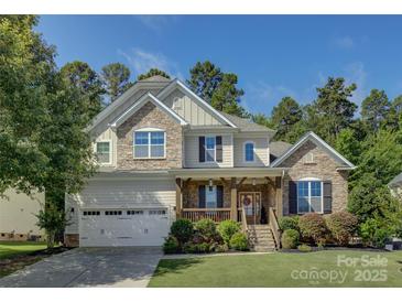 Charming two-story home boasts stone accents, a welcoming front porch, and a well-manicured lawn at 17537 Caddy Ct, Charlotte, NC 28278