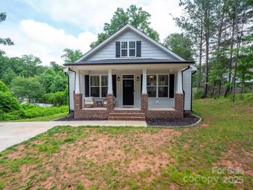 Charming home featuring a brick-lined front porch and beautifully maintained landscaping at 720 4Th St, Stanley, NC 28164