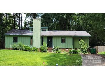 Charming single-story home with unique exterior paint and a well-manicured front lawn at 7705 Stone Canyon Ln, Charlotte, NC 28227