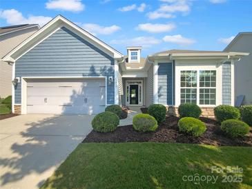 Charming home featuring manicured landscaping, a two-car garage and blue siding at 13419 Morgan Lee Ave, Charlotte, NC 28213