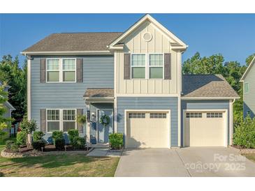 Charming two-story home with a three car garage, light blue siding and a welcoming front porch at 4113 Bent Green Ln, Monroe, NC 28112
