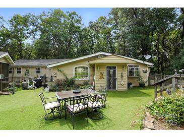 An eye-level shot showcases the back of the home with an outdoor dining set on an artificial lawn at 4412 Dobys Bridge Rd, Fort Mill, SC 29707