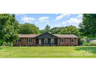 Charming brick ranch-style home with a lush front lawn and mature trees, creating a serene curb appeal at 9410 Mountain Aire Cir, Charlotte, NC 28214