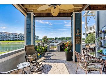 A covered patio with a fan, outdoor seating, and a view of the lake at 1007 Southwest Dr, Davidson, NC 28036