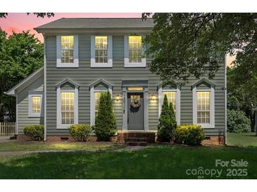Charming two-story home with a well-manicured lawn, decorative shrubs, and a welcoming front entrance at 13010 Indian Hills Ln, Charlotte, NC 28278