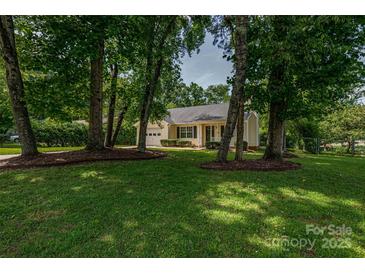 Charming home nestled among mature trees with lush green lawn and manicured landscaping at 1801 Teddington Dr, Charlotte, NC 28214
