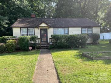 Charming single-story home with a well-manicured lawn and established landscaping at 2411 Rebecca Ave, Charlotte, NC 28208