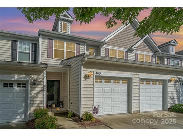 Charming townhome with attached two-car garage, complemented by manicured landscaping and warm exterior lighting at 460 Clouds Way, Rock Hill, SC 29732