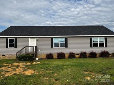 Charming single-story home with gray siding, black shutters, and well-maintained landscaping at 5707 S Rocky River Rd, Monroe, NC 28112