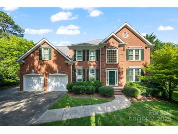 Beautiful two-story brick home featuring a well-manicured lawn and a two-car garage at 8900 Cumbria Ct, Huntersville, NC 28078
