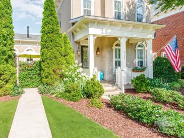 Charming home exterior featuring a covered porch, landscaped yard, and an American flag display at 9730 White Frost Rd, Charlotte, NC 28277