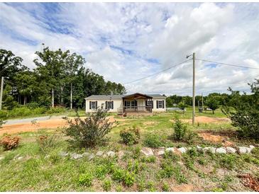 Charming single-story home with a inviting front porch and surrounded by lush greenery at 5321 State Line Rd, Marshville, NC 28103