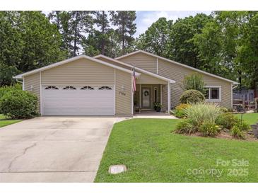 Charming single-story home with an attached garage and a well-manicured front lawn at 7164 Moss Point Dr, Charlotte, NC 28277