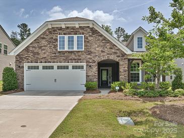 Charming stone and siding home with a two-car garage and inviting front yard at 15614 Aviary Orchard Way, Charlotte, NC 28278
