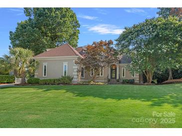 Charming one-story home with a manicured lawn, mature trees, and a welcoming entrance at 15724 Eagleview Dr, Charlotte, NC 28278