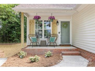 Charming front porch with comfortable seating and decorative hanging flower baskets at 3100 Hickory Grove Dr, Monroe, NC 28110
