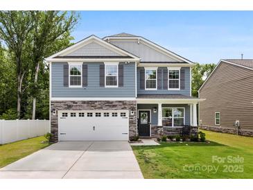 Charming two-story home with stone accents, well-manicured lawn, and an attached two-car garage at 3734 Stanley Creek Dr, Mount Holly, NC 28120