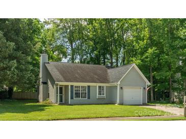 Charming single-story home with a manicured lawn, attached garage, and inviting front entrance at 5019 Poplar Glen Dr, Matthews, NC 28104