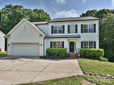Charming two-story home with a two-car garage, landscaped yard, and classic architectural details at 7309 Rock Hampton Ct, Harrisburg, NC 28075