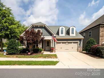 Charming home featuring a two-car garage,dormer windows, and a manicured lawn with mature tree at 741 Garrett Green Way # 64, Fort Mill, SC 29715