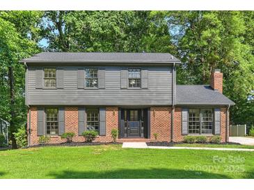 Charming two-story home with a brick and gray wood exterior, well-manicured lawn, and a welcoming front entrance at 811 Ashmeade Rd, Charlotte, NC 28211