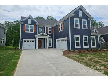 New construction home with blue siding, white trim, and a two-car garage plus a one car garage at 8231 Annsborough Nw Dr, Concord, NC 28027