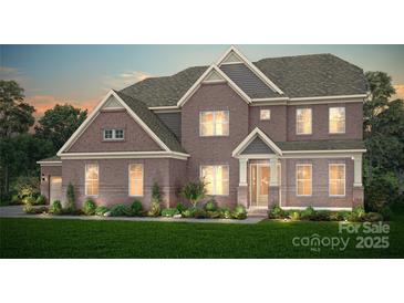Stunning brick home with beautiful landscaping and a welcoming front entrance and a two-car garage at 9112 Ansley Park Pl # 266, Huntersville, NC 28078