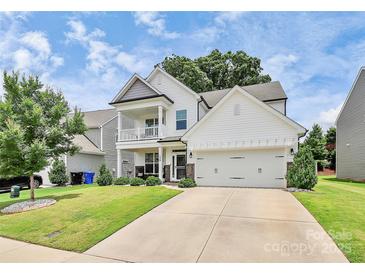Beautiful two-story home featuring a front porch, a two-car garage, and a well-manicured lawn at 139 Suggs Mill Dr, Mooresville, NC 28115