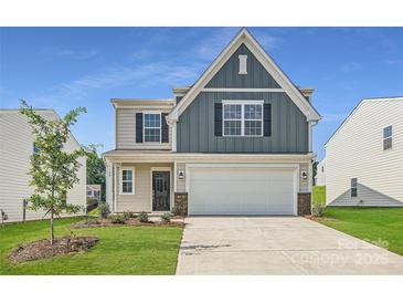 Charming two-story home boasts a classic design, complemented by a well-manicured lawn and a two-car garage at 140 Astor St, Troutman, NC 28166