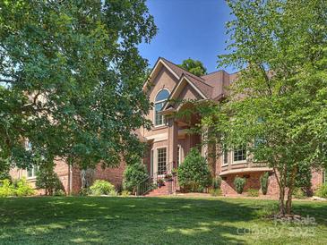 Stately home with a manicured lawn, brick accents, and mature trees framing the facade at 2317 Houston Branch Rd, Charlotte, NC 28270