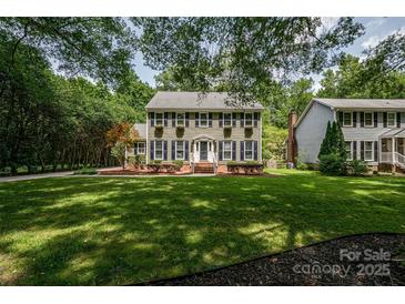 Charming two-story home with shutters, window box planters, brick stairs, and a lush green lawn at 5014 Quail Canyon Dr, Charlotte, NC 28226