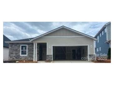 Charming single-story home featuring stone accents and an attached two-car garage, perfect for modern living at 5602 Caneel Ln # 1222, Denver, NC 28037