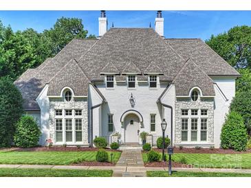 Striking white painted brick home with well manicured lawn and stone pathway to front door at 6314 Saint Stephen Ln, Charlotte, NC 28210