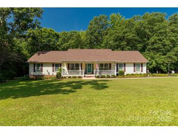 Charming ranch home with a covered porch, lush lawn, and mature trees at 637 Freemont Dr, Lancaster, SC 29720