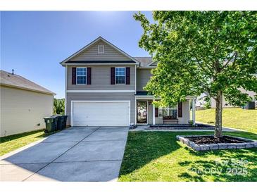 Charming two-story home featuring a two-car garage, well-manicured lawn, and a welcoming front porch at 722 Overlook Rd, Lowell, NC 28098